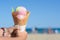 Little girl holding waffle cone with scoops of delicious colorful ice cream at beach on sunny summer day, closeup. Space for text