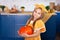 Little girl holds big pumpkin in kitchen at home. Harvesting. Healthy nutrition, vegetarianism, vitamins, vegetables. Cute child g