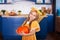 Little girl holds big pumpkin in kitchen at home. Harvesting. Healthy nutrition, vegetarianism, vitamins, vegetables. Cute child g
