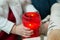 Little girl holds a candle in a big red candlestick. Christmas