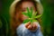 A little girl holds a green lupin leaf in front of her. Selective focus