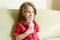 Little girl holds inhaler mask at home