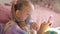 Little girl holds inhaler mask at home. Sick kid breathes through a nebulizer. Baby using equipment to treat asthma or