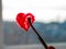 Little girl holds paintbrush in hand drawing red heart on window glass. Valentine`s day love, dating, quarantine leisure