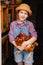 a little girl holds a red hen in a chicken coop. laying hen.