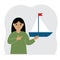 A little girl holds a sailing yacht in his hand. Concepts of freedom, hope and big plans. Hobby.