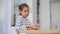 Little girl holds white furry little mouse on white background. Funny fluffy pet. Beautiful curious spotted mouse.