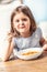 Little girl at home in the kitchen tasting Italian spaghetti