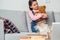 Little girl at home sitting hugging teddy bear relaxed