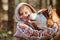 Little girl in hoodie hugs Siberian Husky dog, cute friendly meeting of brown Husky dog and girl