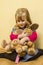 Little Girl Hugging Stuffed Animals