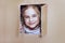 Little girl inside cardboard playhouse