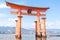 Little girl at the Itsukushima shrine great orange gate O-torii at the Miyajima island in Hiroshima Japan
