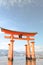 Little girl at the Itsukushima shrine great orange gate O-torii at the Miyajima island in Japan
