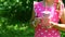 Little girl with jar of yogurt in the garden among the raspberry bushes, closeup. Authentic lifestyle image. Seasonal harvest crop