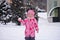 Little girl joyfully plays snowballs
