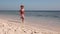 A little girl joyfully runs along the sea on the sand on the shore of Red Sea