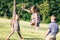 Little girl jumping through the elastic, playing with other children.