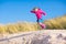 Little girl jumping in sand dunes