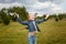 Little girl jumping and throwing green grass on lawn in spring park. Happy joyfull emotion, carefree childhood, outdoors activity