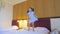 A little girl jumps on the bed in a hotel room, has fun and enjoys life.