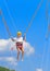 A little girl jumps high on a trampoline with rubber ropes again