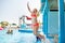 A little girl jumps into the pool at the water park during the summer vacation. Greece