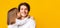 Little girl kissing her happy father over yellow background