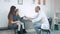 Little girl kissing her mom and smiling male doctor giving her candy for good behaviour