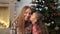 Little girl kissing her mother at Christmas