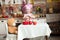 Little girl in the kitchen in a pink chef`s hat and apron stands near the table, feeds the bear, rejoices and laughs