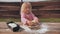 Little girl kneads the dough with her hands.