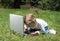 The little girl with laptop on a glade