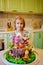 little girl with a large cake with figures of fairy-tale characters