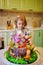 little girl with a large cake with figures of fairy-tale characters