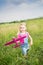 Little girl, launches a toy plane with the background of green grass. Child launches a toy plane. Beautiful little girl, stands on