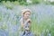 Little girl in lavender field. kids fantasy. Smiling girl sniffing flowers in summer purple lavender field