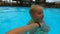 Little girl learning to swim in the pool with father