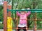 A little girl learns to climb ladders and crossbars