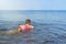 Little girl learns to swim on an rubber ring. Side view