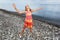 Little girl lifted hands upwards on stony beach