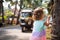 A little girl with light curly hair - with an Indian auto rickshaw in the background.