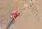 Little Girl with light hair falls from the mountain of sand