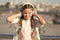 Little girl listening music enjoy favorite song. Girl with headphones urban background. Positive influence of music