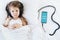 Little girl listening to children`s audiobook in mobile phone in headphones before sleeping in bed. Education, child development.