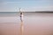 Little girl with lond hair in beautiful dress running on sea beach . Child playing on ocean beach. Sea