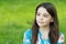 Little girl with long hair relaxing in park sunny day green grass background, united with nature concept