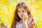 Little girl with long hair in a white dress rejoices in a field with flowers