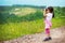 Little girl looking through binoculars outdoor. She is lost.