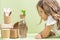 Little girl looking at branch in a bottle along with eco-frendly containers